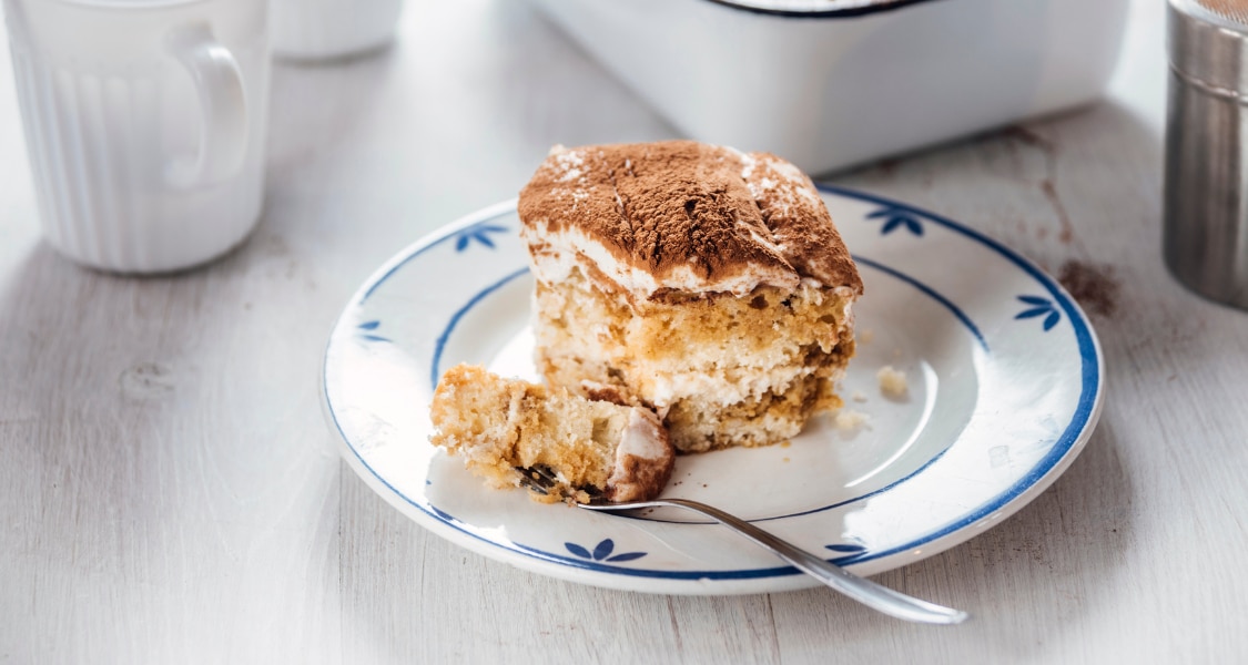 Tiramisú en vaso con capas de soletas, mezcla de queso crema y yogurt, y Bebida de Almendra Café, decorado con frutos rojos